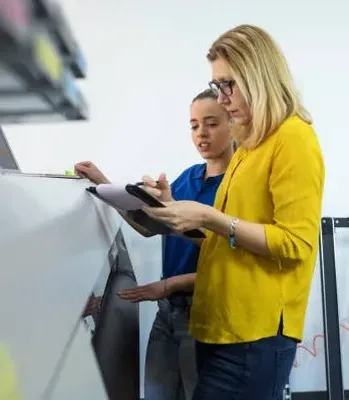 Fotografía de una mujer de amarillo revisando material de la imprenta en Monterrey: Carnevali